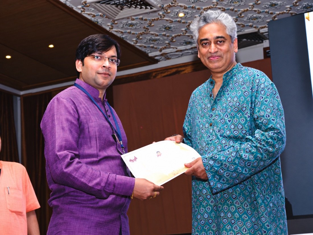 Niranjan Mahawar presenting a certificate on stage